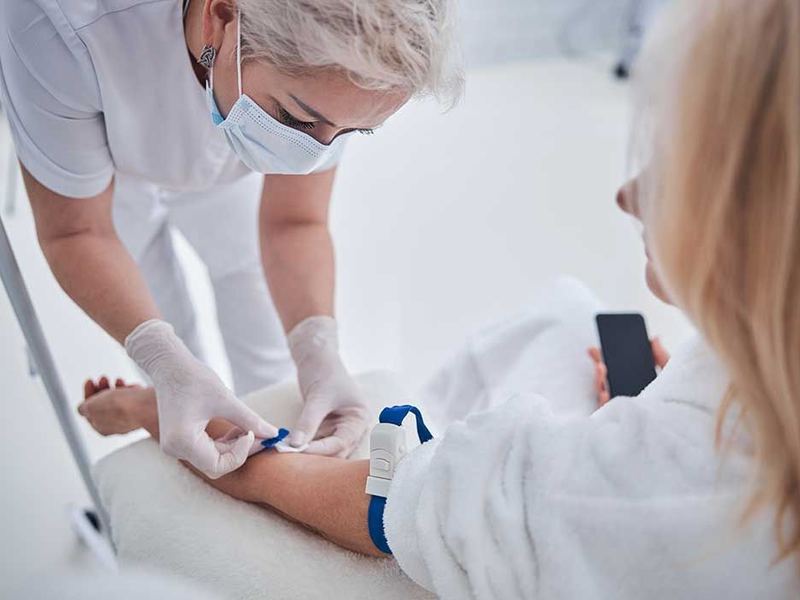 A nurse preparing a patient's arm for a blood draw