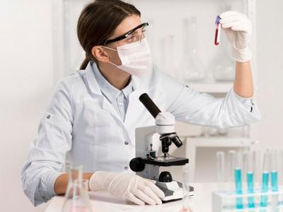 A scientist examining a specimen tube in the laboratory